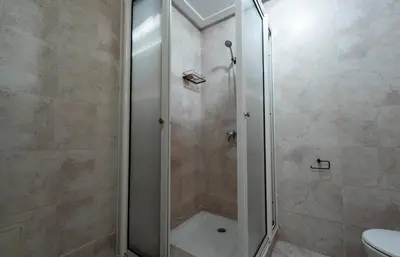a shower with a glass door in a bathroom at La maison du soleil in Oulad Akkou