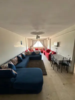 a living room with a blue couch and a table at Bright & comfortable apartment in Marrakech