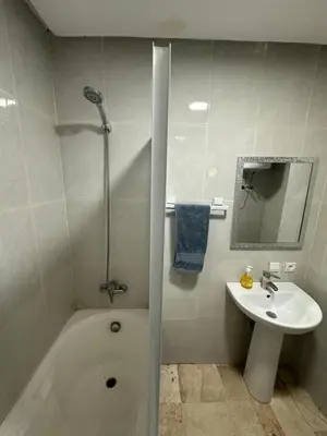 a bathroom with a bath tub and a sink at Bright & comfortable apartment in Marrakech