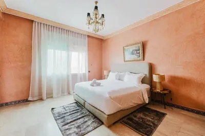 a bedroom with a large bed and a chandelier at Dar Saada Private Villa in Marrakech