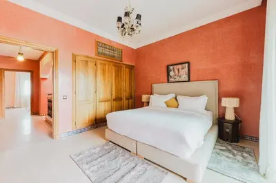 a bedroom with a white bed and orange walls at Dar Saada Private Villa in Marrakech