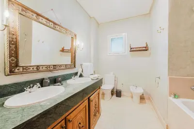 a bathroom with two sinks and a toilet and a mirror at Dar Saada Private Villa in Marrakech