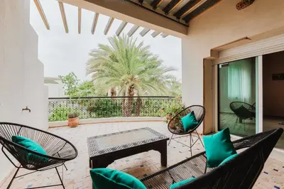 a patio with chairs and a table and a palm tree at Dar Saada Private Villa in Marrakech