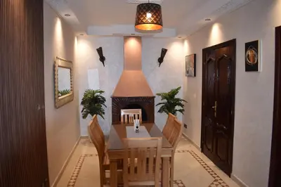 a dining room with a table and a fireplace at Apartment A Zaitone G5 N3 in Marrakech