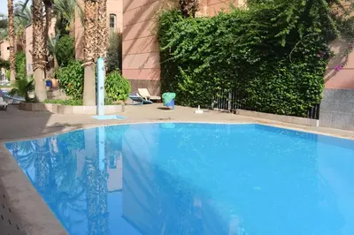 a large blue swimming pool in front of a building at Apartment A Zaitone G5 N3 in Marrakech