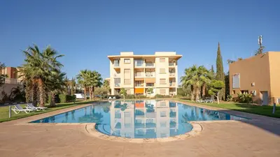a large swimming pool in front of a building at Résidence Coralia, 10 minutes de Guéliz, place Jemaa El Fna in Marrakech