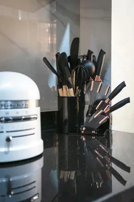 a black counter top with a container of kitchen utensils at Résidence Coralia, 10 minutes de Guéliz, place Jemaa El Fna in Marrakech