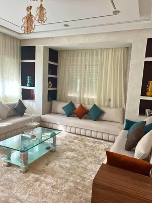 a living room with two couches and a glass table at Dar Hanane in El Gouassem