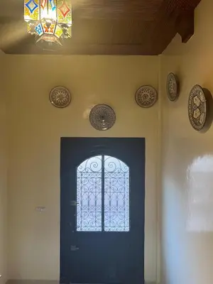 a door with a stained glass window and plates on the wall at Dar Hanane in El Gouassem