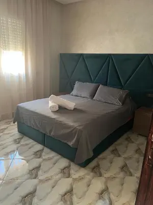 a bed with a blue headboard in a bedroom at Dar Hanane in El Gouassem