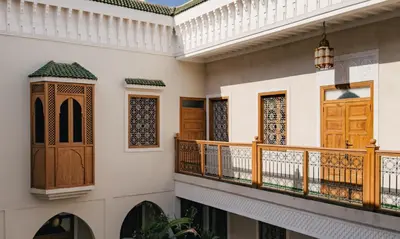 a balcony in a house with wooden doors at Amanar Marrakech Boutique Hotel & Riad in Marrakech