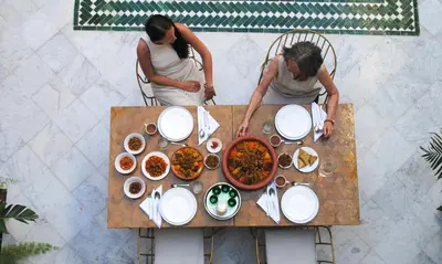 two people sitting at a table with food at Amanar Marrakech Boutique Hotel & Riad in Marrakech