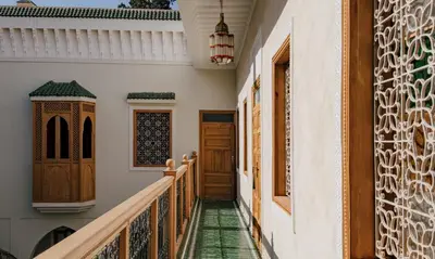 a corridor of a house with wooden doors and green tiles at Amanar Marrakech Boutique Hotel & Riad in Marrakech
