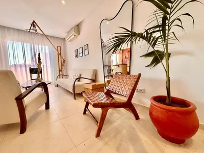 a living room with a chair and a potted plant at Elegant & Cosy Cocoon in Central Gueliz in Marrakech