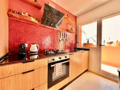 a kitchen with a stove and a red wall at Elegant & Cosy Cocoon in Central Gueliz in Marrakech