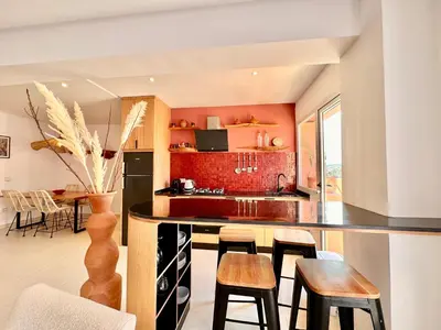 a kitchen with orange walls and a black counter top at Elegant & Cosy Cocoon in Central Gueliz in Marrakech