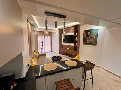 a kitchen and living room with a island in a room at Appartement Chic avec Terrasse à Gueliz in Marrakech