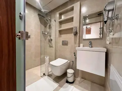 a bathroom with a toilet and a glass shower at Appartement Chic avec Terrasse à Gueliz in Marrakech
