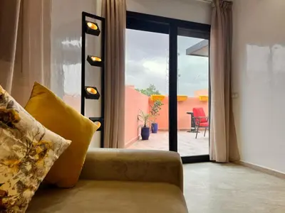a living room with a couch and a sliding glass door at Appartement Chic avec Terrasse à Gueliz in Marrakech