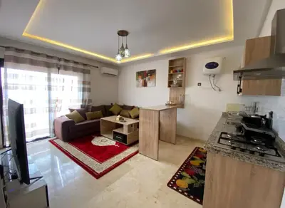 a kitchen and a living room with a couch and a table at LUXURY Apartment Hivernage & Gueliz - Pool, Parking & 24h Security in Marrakech