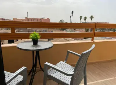 a table and two chairs and a table on a balcony at LUXURY Apartment Hivernage & Gueliz - Pool, Parking & 24h Security in Marrakech