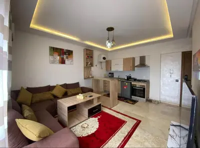 a living room with a couch and a kitchen at LUXURY Apartment Hivernage & Gueliz - Pool, Parking & 24h Security in Marrakech