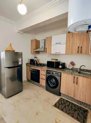 a kitchen with a stainless steel refrigerator and a dishwasher at Studio cosy avec piscine à Gueliz in Marrakech