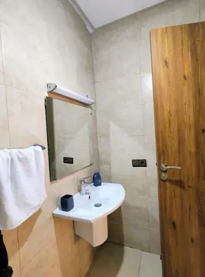a bathroom with a sink and a mirror and a door at Studio cosy avec piscine à Gueliz in Marrakech