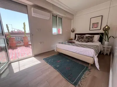 a bedroom with a bed and a large window at Rooftop Terrasse - Centre Gueliz in Marrakech