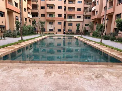 a swimming pool in the middle of a building at Appartement moderne Piscine, Wifi fibre, parking in Marrakech