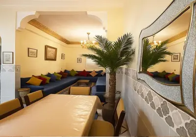 a restaurant with couches and a table and a mirror at Appart Nour in Marrakech