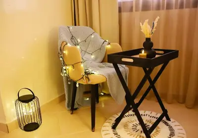 a room with a chair and a table with a lamp at Charming apartment in a tourist village Premium village in Marrakech