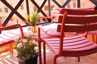 a group of chairs sitting on a balcony with flowers at Charming apartment in a tourist village Premium village in Marrakech