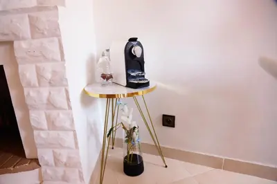 a table with a radio and a vase of flowers at Charming apartment in a tourist village Premium village in Marrakech
