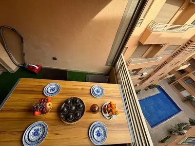 a wooden table with plates of food on it at Luxuriöse Wohnung mit Pool und Netflix in Marrakech