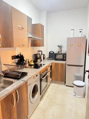 a kitchen with a refrigerator and a washer and dryer at Luxuriöse Wohnung mit Pool und Netflix in Marrakech