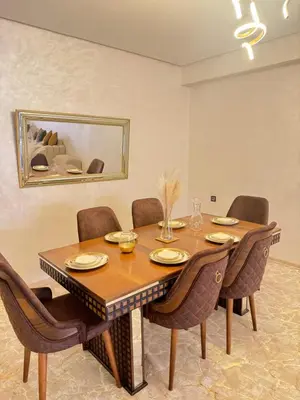 a dining room with a wooden table and chairs at Luxuriöse Wohnung mit Pool und Netflix in Marrakech