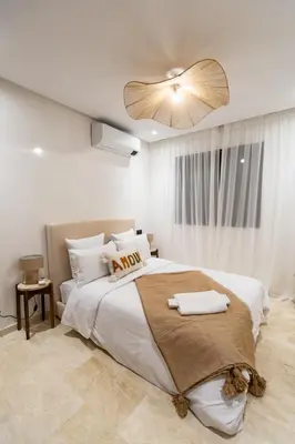 a bedroom with a large bed with a ceiling fan at Modern Apartment in Victor Hugo Walk to Gueliz City Center in Marrakech