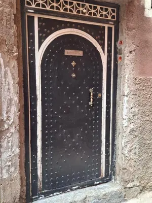 a black door in a building with a sign on it at Étoile de fatima - au cœur de la médina in Marrakech