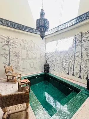 a swimming pool in the middle of a room with a wall at Riad Émeraude Privé 3 chambres avec piscine Médina Marrakech in Marrakech