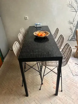 a black table with a bowl of oranges on it at Riad Émeraude Privé 3 chambres avec piscine Médina Marrakech in Marrakech