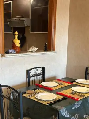 a table with chairs and plates on top of it at Central Gueliz Apartment Bright & Peaceful in Marrakech