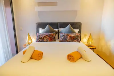 a bedroom with a white bed with orange and blue pillows at Chic Marrakech Getaway with Pool, Gym & Security in Marrakech