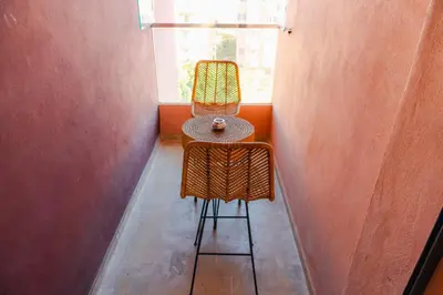 a chair sitting in a room with a window at Chic Marrakech Getaway with Pool, Gym & Security in Marrakech