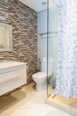 a bathroom with a toilet and a glass shower at Chic Marrakech Getaway with Pool, Gym & Security in Marrakech