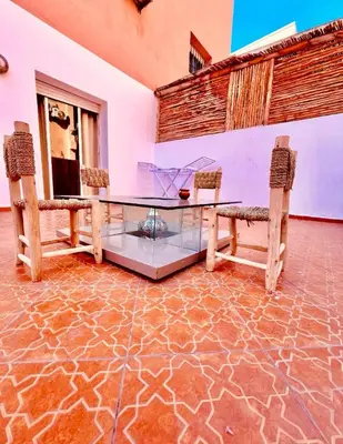 a room with a glass table and two benches at مراكش سنتر جيليز احسن موقع في مراكش in Marrakech