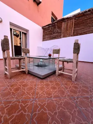 a glass table with two benches on a patio at مراكش سنتر جيليز احسن موقع في مراكش in Marrakech