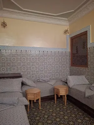 a living room with two beds and two tables at Lalla Fatima - a deux pas de la Bahia in Marrakech