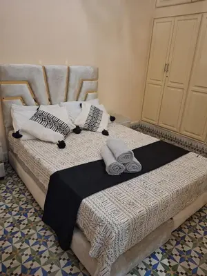 a bedroom with a bed with towels on it at Lalla Fatima - a deux pas de la Bahia in Marrakech