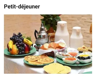 a table with plates of food and fruit on it at Lalla Fatima - a deux pas de la Bahia in Marrakech